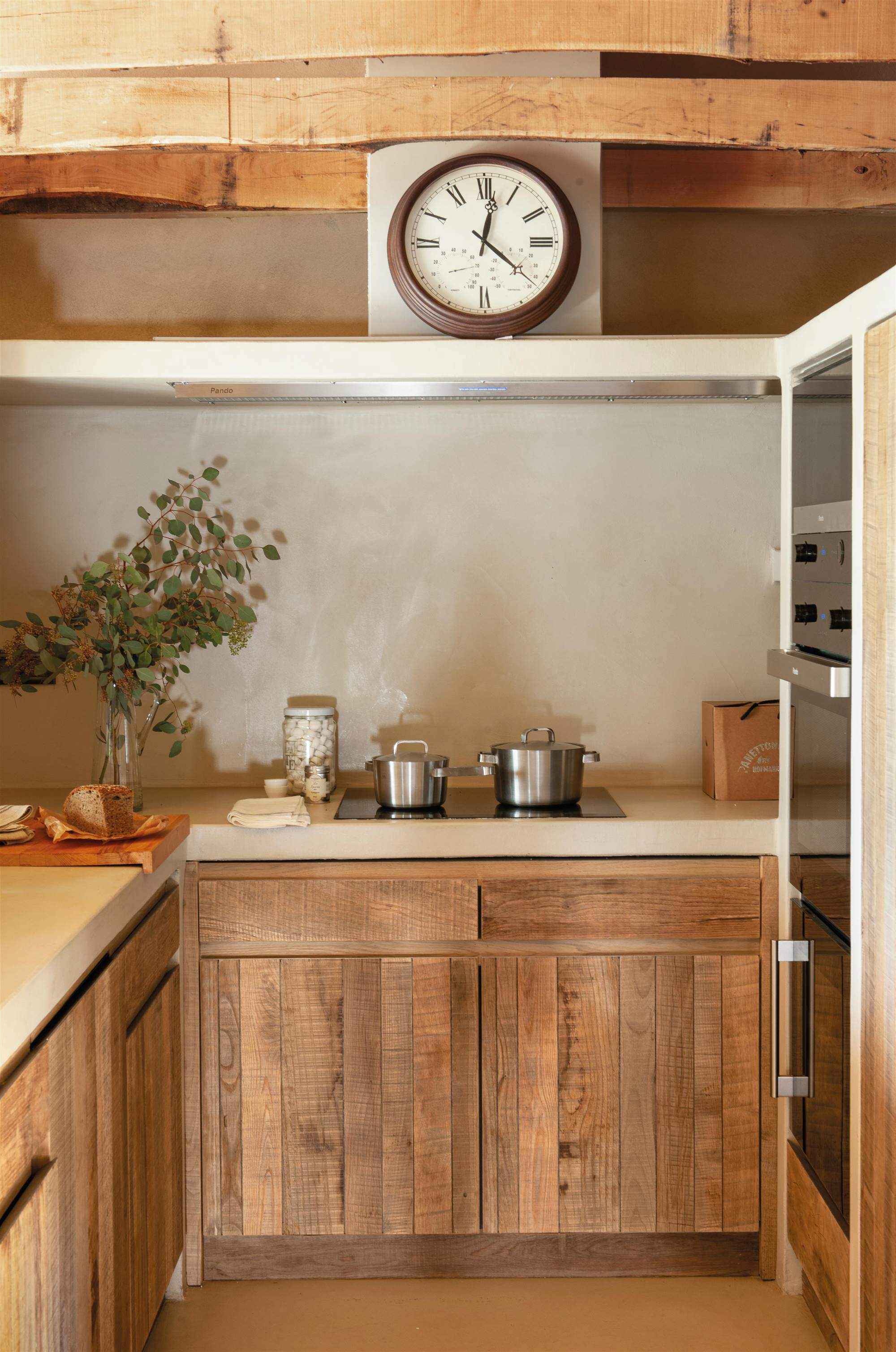 Cocina de obra con frentes de madera de roble y encimera y revestimiento de microcemento.