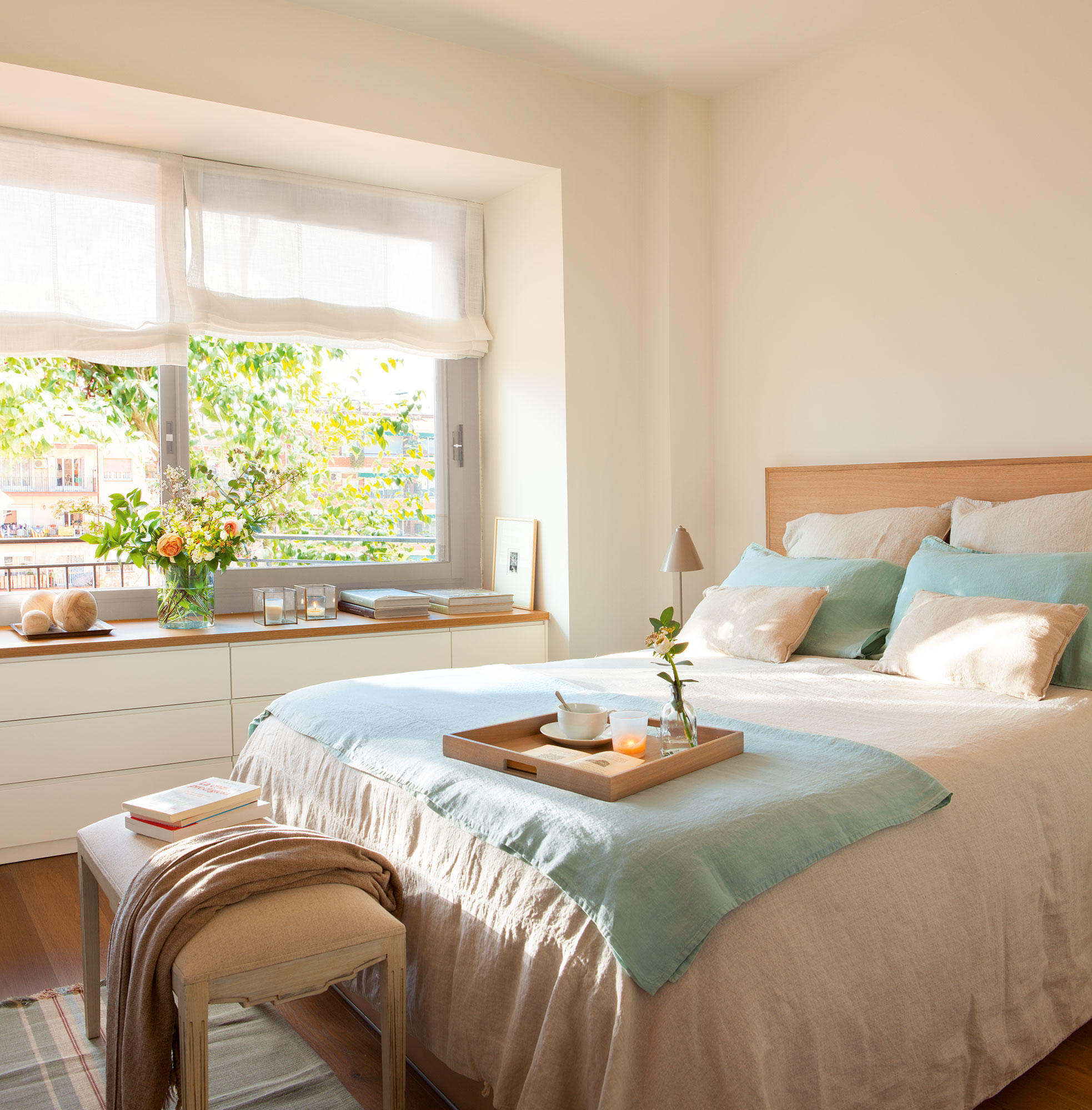 Dormitorio con mueble debajo de la ventana