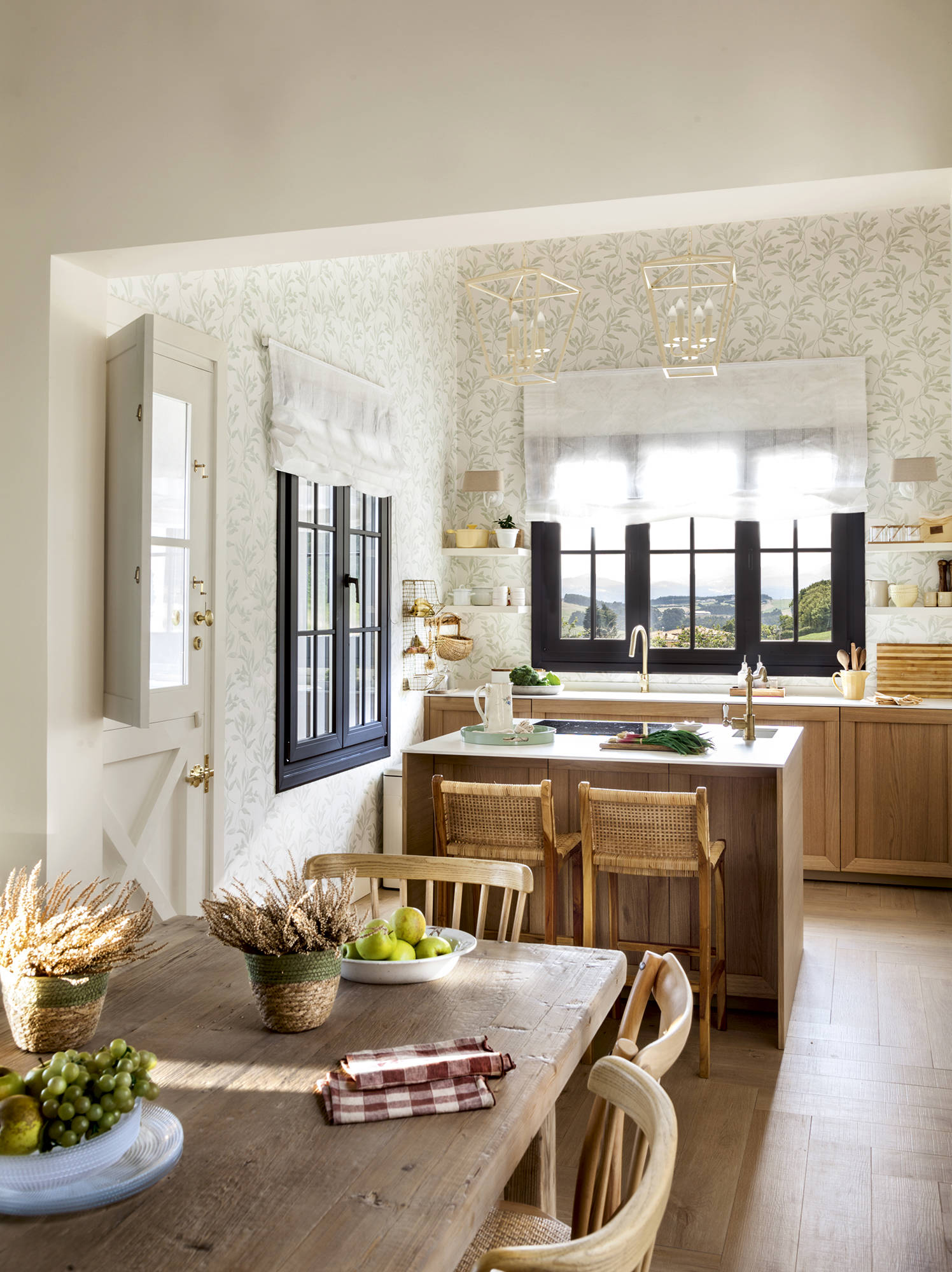 Cocina rústica con barra, dos taburetes y comedor con mesa de madera.