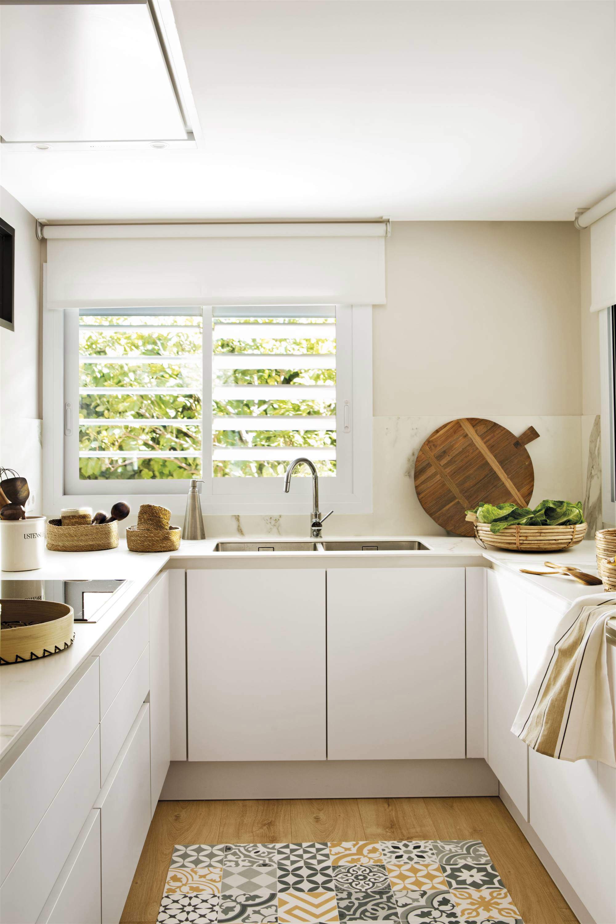 Cocina con muebles blancos y suelo de madera