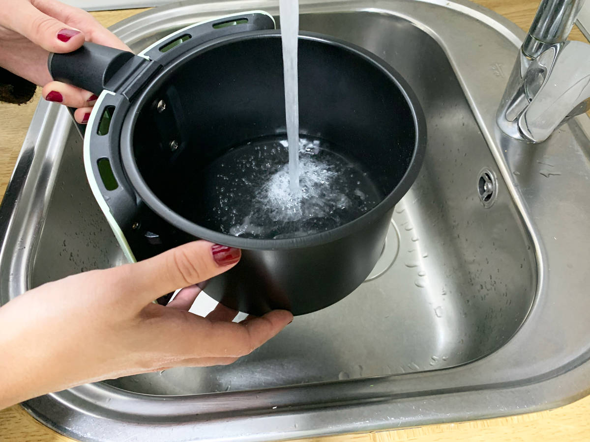 Introduciendo agua en la cesta de la freidora de aire.