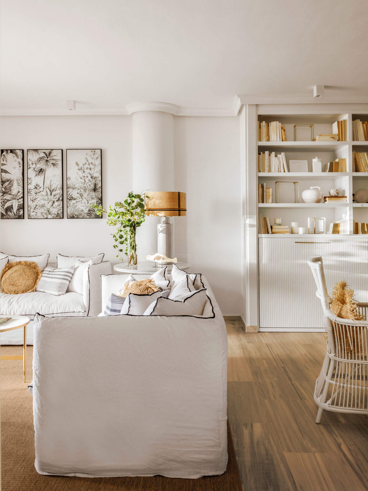 Salón con librería y mueble cama lacado en blanco